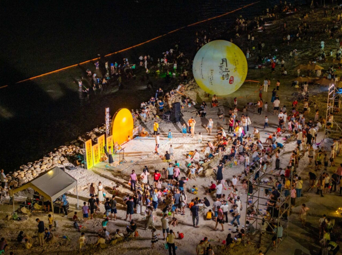 夜幕降临，七彩沙滩人头攒动。洪海摄