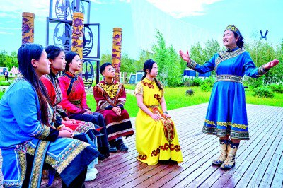     黑龙江双鸭山市饶河县四排赫哲风情旅游园区，赫哲族伊玛堪省级代表性传承人卢艳华（右一）在传授说唱技艺。王晨吉摄/光明图片