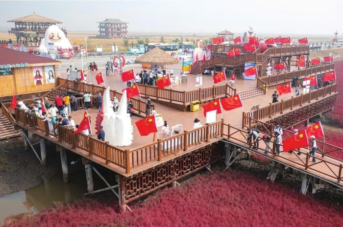         红海滩上国旗飘扬。受访者供图
