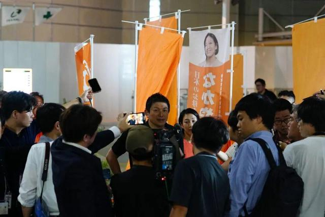7月13日，在日本千叶县，参政党党首神谷宗币（中）在街头演说活动后接受媒体采访。新华社记者贾浩成摄