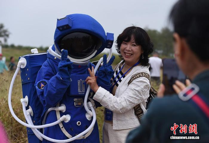 10月11日，山东海阳，游客与身穿“宇航服”的人偶合影。中新社记者 王娇妮 摄