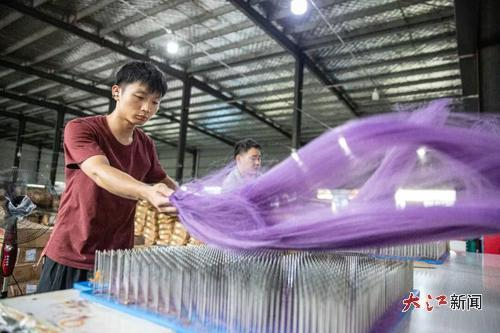 宜春市水江镇的一假发企业工人正在梳理假发。