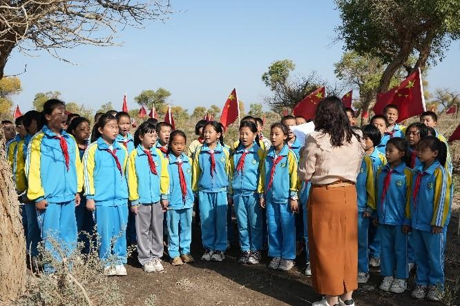 图4&nbsp;小学生们正在跟着教师诵读“胡杨精神”（李小虎 摄）
