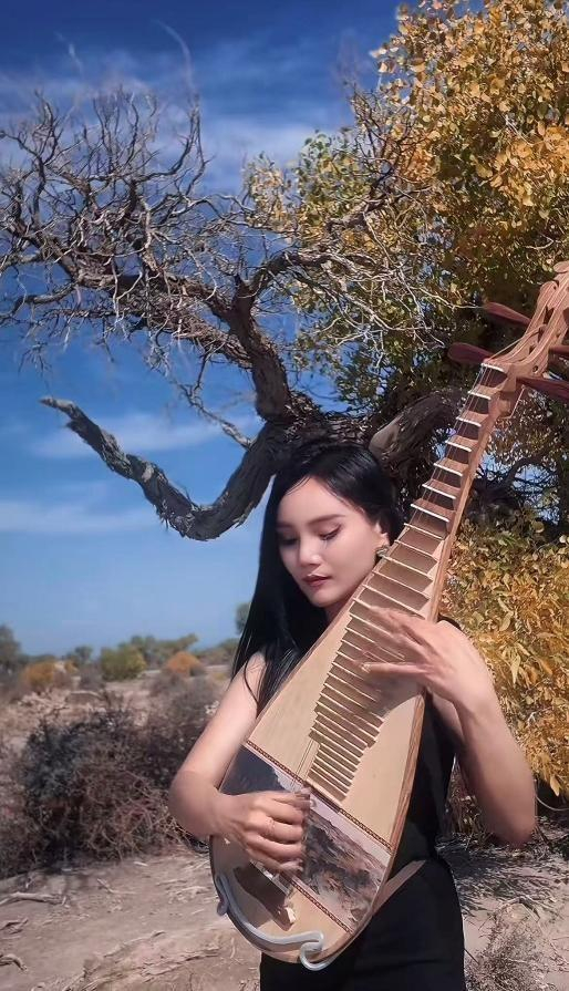 图10 “琵琶李阳“正在伊吾胡杨林间演奏琵琶（达人供图）