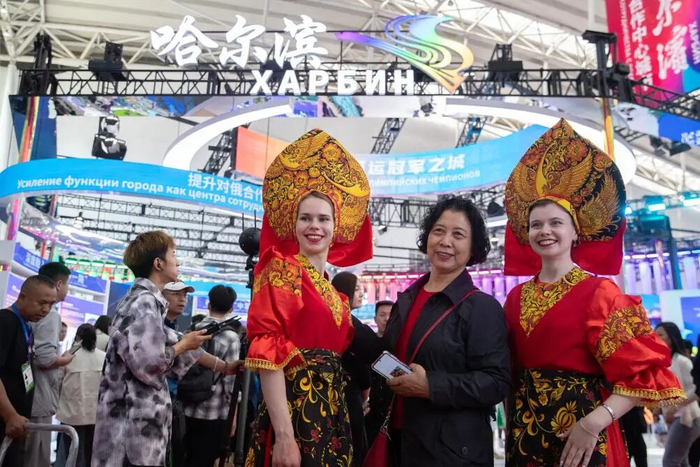 ▲2024年5月18日，在第八届中俄博览会现场，参会者与俄罗斯演员合影。  新华社记者 张涛 摄