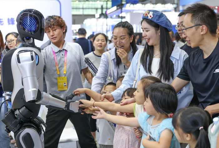   2025年9月6日，在重庆举行的2025世界智能产业博览会上，生活家居机器人与观众握手。新华社记者 陈诚 摄