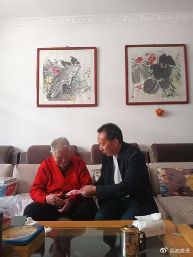 陕西省城固县老龄健康服务中心工作人员上门为百岁老人发放高龄补贴。