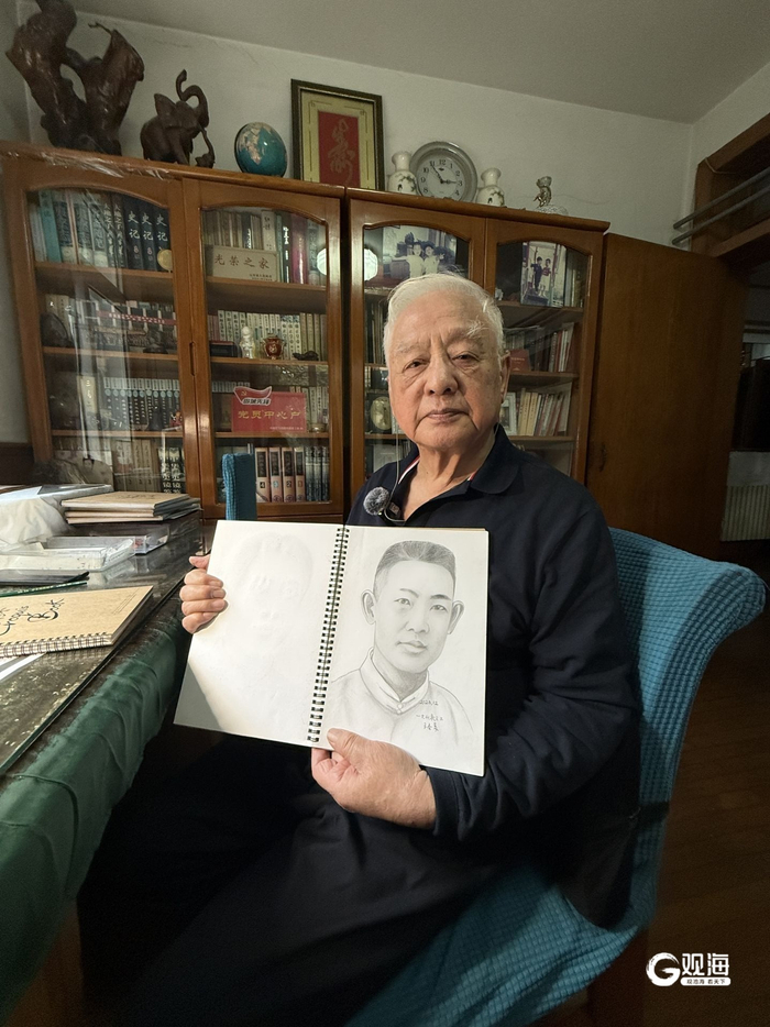 邱镇珂展示“英雄谱”绘画本。青岛早报/观海新闻记者 肖梦婕 摄