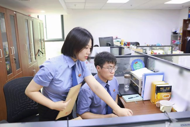 7月，办案检察官与助理开展案情研判。