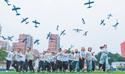 江苏省宿迁市泗洪县新星城西学校，学生们在放飞飞机模型。李佳摄（影像中国）
