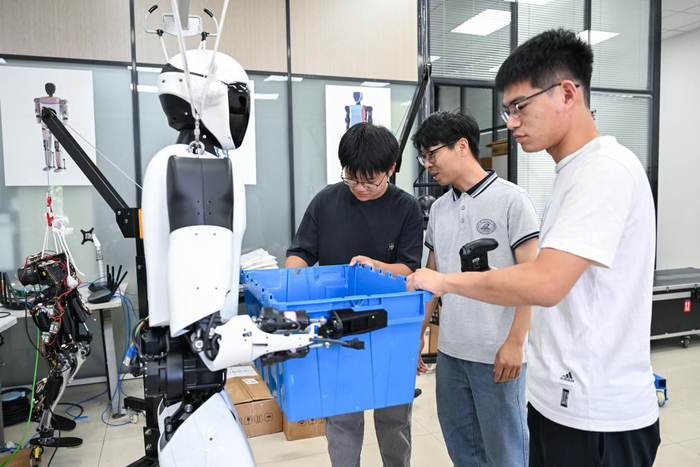 2025年5月29日,华中科技大学机械科学与工程学院,学生对“荆楚”人形机器人进行搬运测试。新华社记者 杜子璇 摄