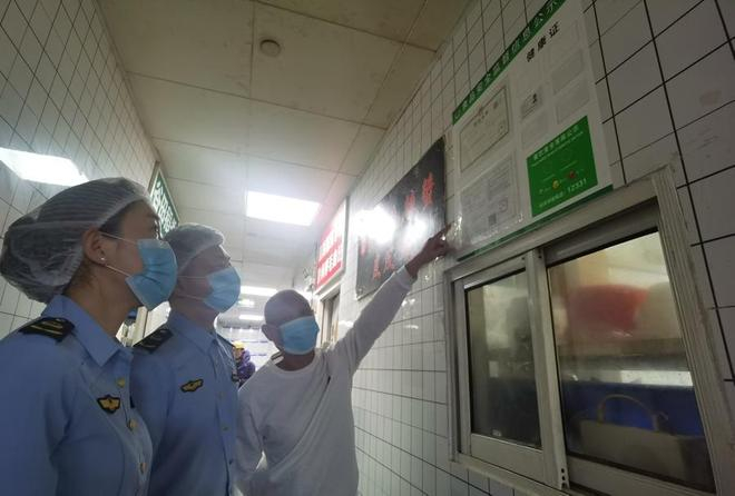  闵行区市场监管局工作人员查验无堂食餐饮店许可情况，要求“一店一证”。 陈玺撼摄