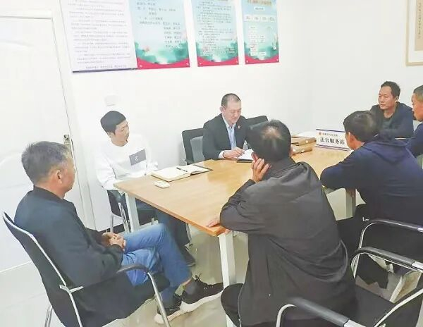 图为河北省安新县人民法院白洋淀人民法庭庭长张林杰（左三）组织案件当事人在调解室进行调解。李楠 摄