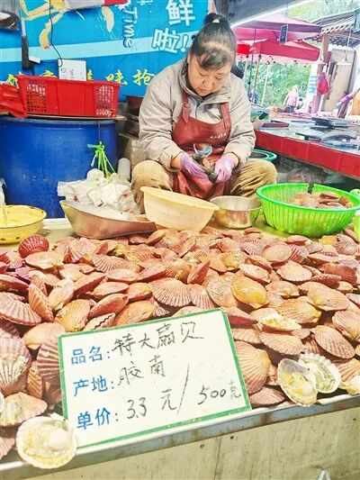 在市北区九江路农贸市场，商户正在加工扇贝。