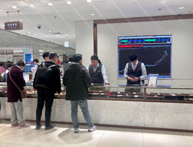 10月27日，在北京市菜市口百货投资金条柜台，顾客正在咨询商品。新华网记者 游苏杭 摄