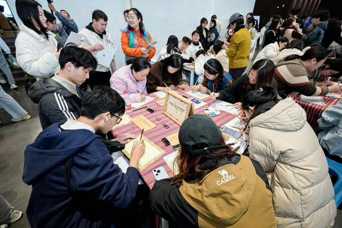 图为:学生体验毛笔字书写“扎西德勒”