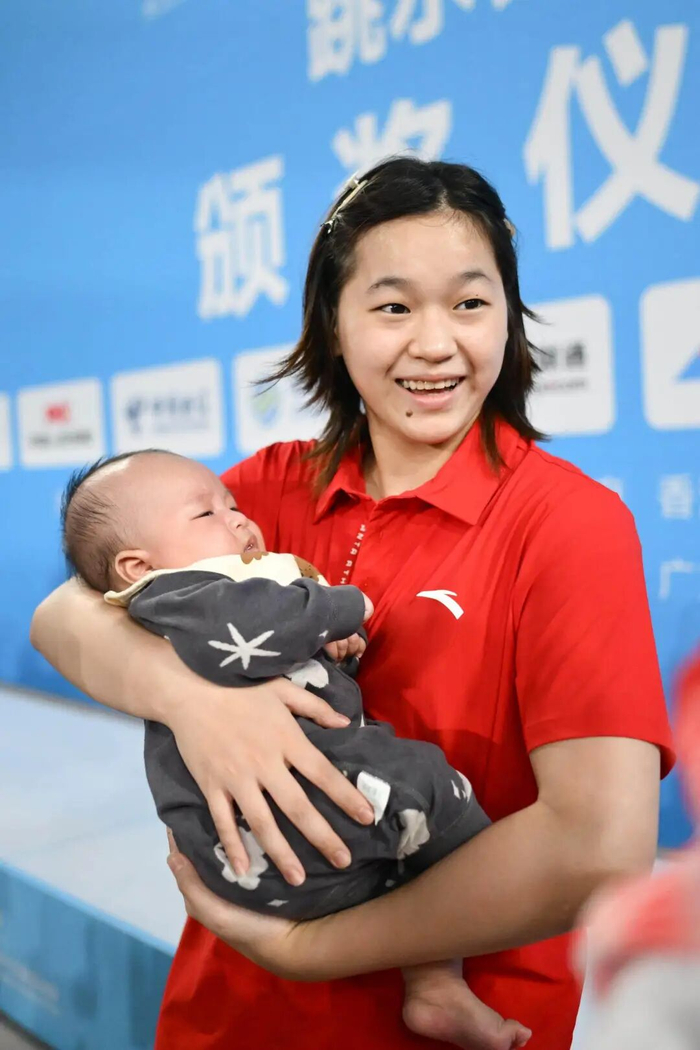 全红婵抱着谢思埸的宝宝合影。图片来源：羊城晚报