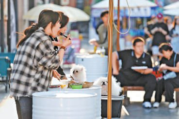 　　年轻人带着宠物打卡市集。本报记者 程功摄