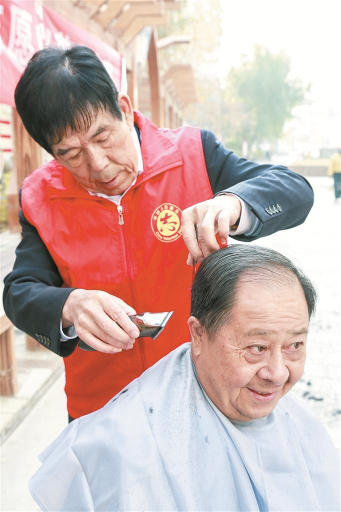     10月29日，六师五家渠市人民路街道北海东街社区党员马登先（左）为小区老人义务理发。闻新  摄