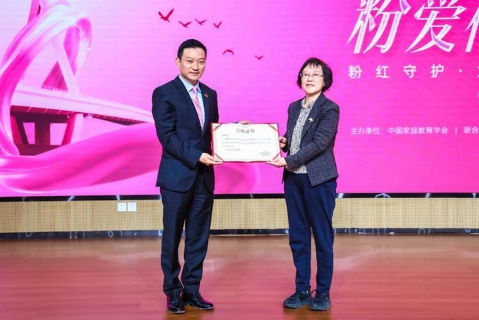 ▲中国家庭教育学会副会长王耘向爱康集团创始人、董事长兼CEO张黎刚颁发合作证书