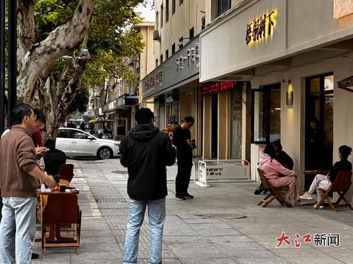 一咖啡馆前不少人在聊天、拍照。全媒体记者 谢梦丽 摄