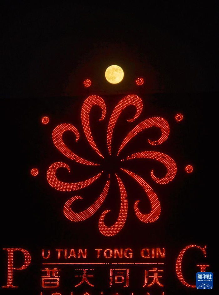 11月5日晚在江苏省南通市崇川区拍摄的“超级月亮”和普天同庆主题霓虹灯（无人机照片）。新华社发（许丛军摄）