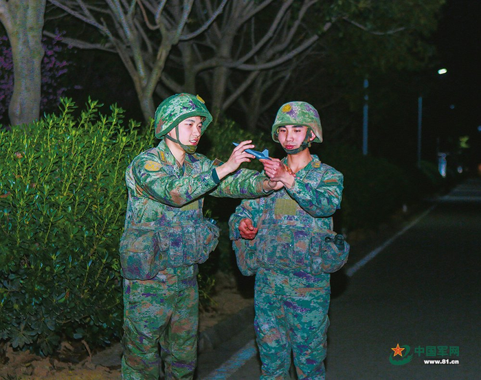 　　一位副连长（左）在代职期间与骨干交流训练心得。吴乾万摄