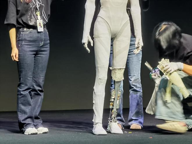 ▲小鹏机器人团队在台上剪开小鹏全新一代IRON的腿部覆盖件