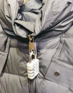 为防止顾客“蹭穿”，商家为衣服挂上密码锁和巨型吊牌。受访者供图