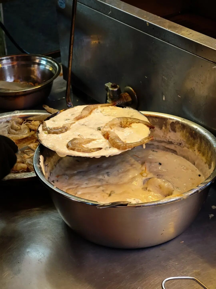 在面糊上铺满鲜虾。图片来源网络