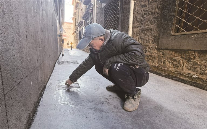 工人正在进行路面硬化。记者 娄梦琳 摄