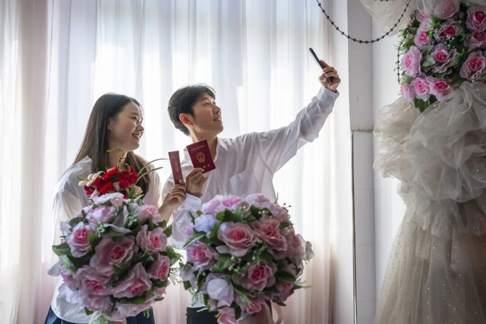 一对新人领取结婚证后拍照留念。肖本祥摄（新华社）