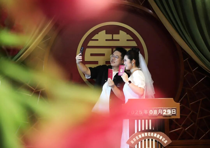 一对新人领取结婚证后拍照留念。杭兴微摄（新华社）