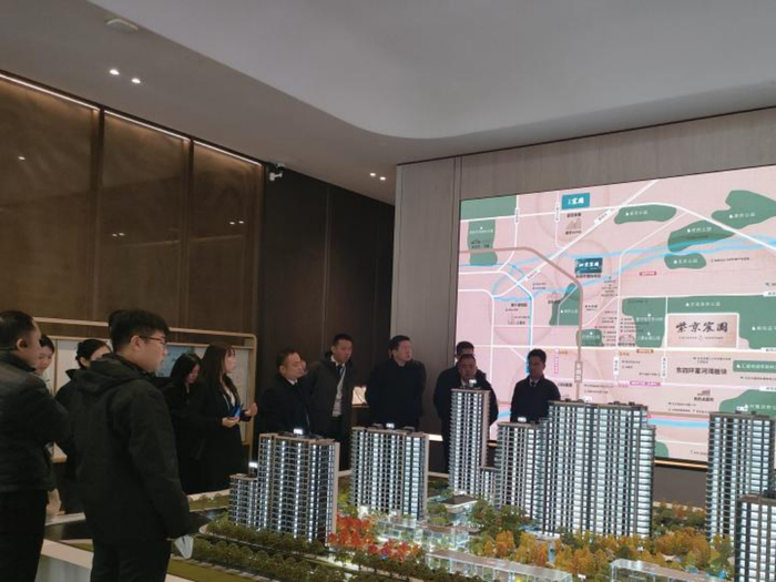 紫京宸园沙盘旁，客户们在听销售讲解。摄影/王文彤