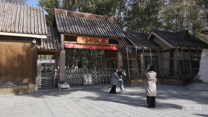 游客在桦林公园前合影  （央广网记者丁安  摄）
