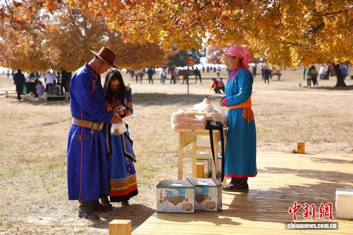  图为在五角枫生态旅游景区内，游客购买传统手工艺奶制品。　麦丽苏 摄