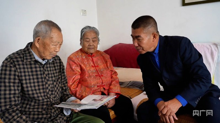 支玉芳与社区干部共同看相册  （央广网记者丁安  摄）