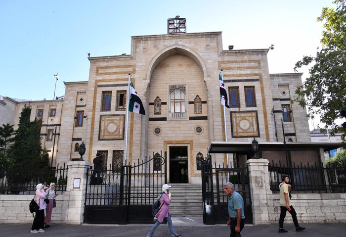 　　10月6日，在叙利亚首都大马士革，行人从立法机构大楼前经过。新华社发（阿马尔·萨法尔贾拉尼摄）