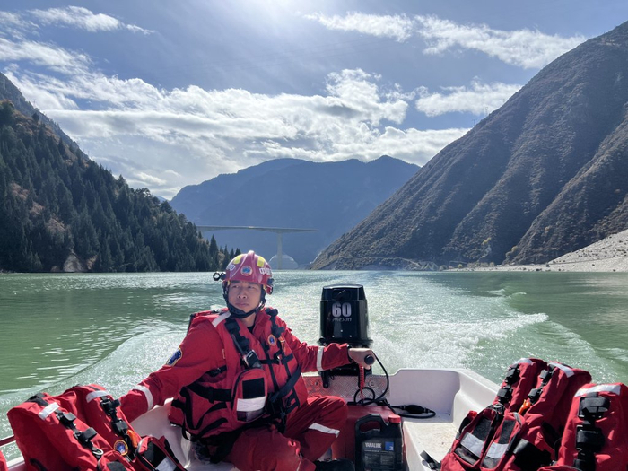 　安能救援人员用冲锋舟运送村民过水库。