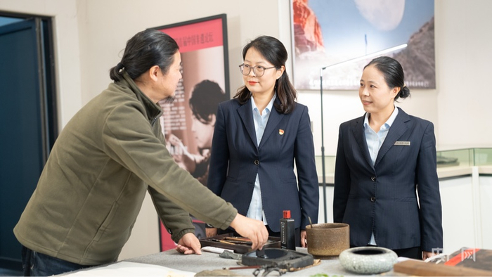 胡雍与中国银行黄山分行工作人员交流工作室发展情况（央广网记者  刘畅司晨  摄）