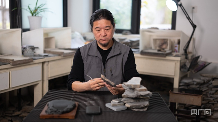 胡雍正在观察研究石材造型（央广网记者  刘畅司晨  摄）