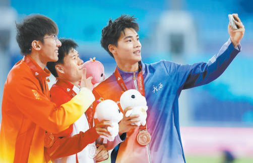 男子短跑100米冠军李泽洋（左）与亚军王胜杰（中）、季军曾克理合影。新华社 供图