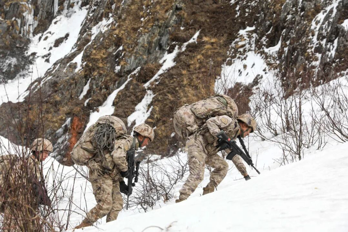 寒风凛冽中，次罗布（右一）与战友屈身前行攀爬险坡