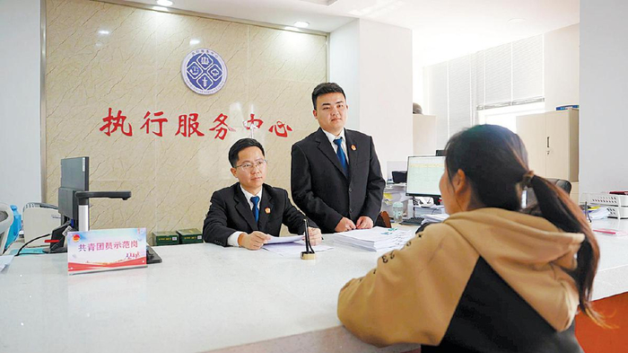 刘毅和同事在法院为来访者讲解个人破产制度。　受访者供图