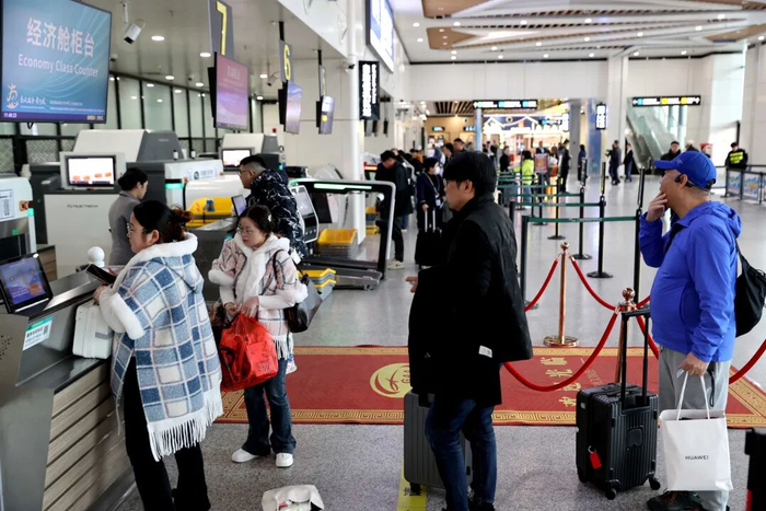 惠州机场旅客出发大厅人头攒动，旅客在有序办理登机手续。