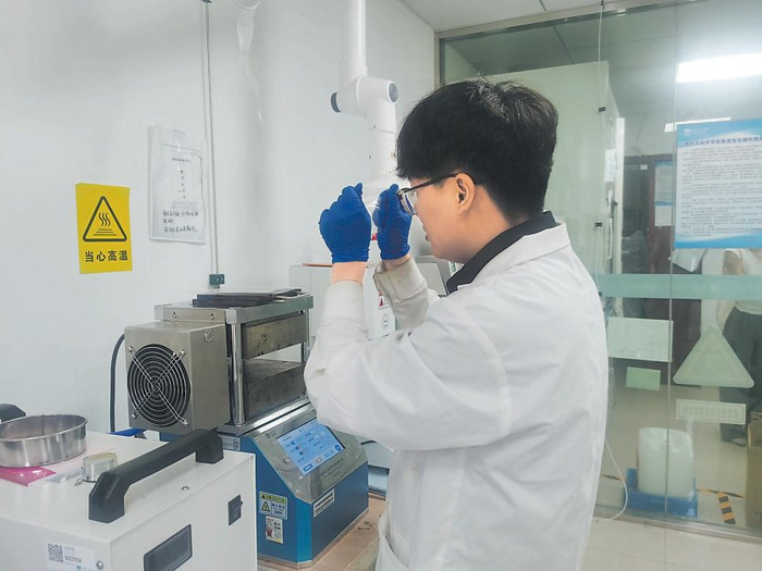 郭凯团队科研人员观察热压成型的生物基材料