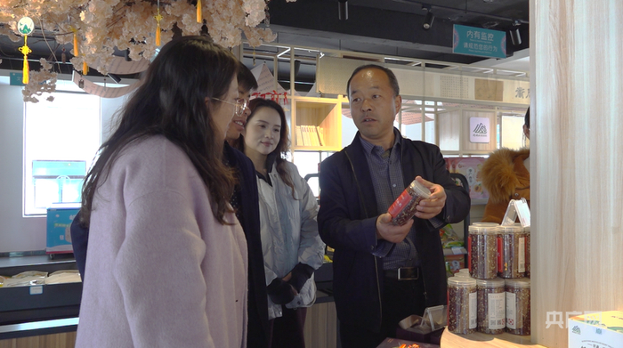 朱学向游客推介当地物产（央广网记者 寇刚 摄）