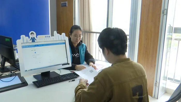 图为工作人员在为企业业主办理员工退休相关业务