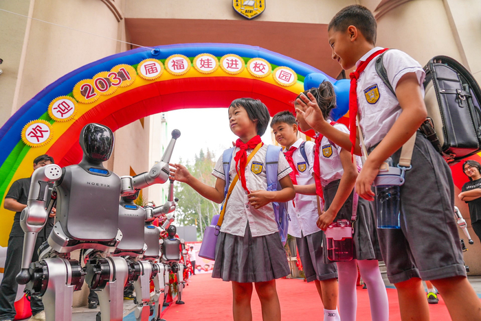 　　智能机器人与师生共迎新学期。