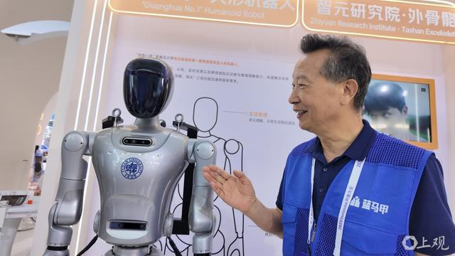 上海老年大学“蓝马甲”志愿者在外滩大会上讲解人形机器人。徐瑞哲 摄